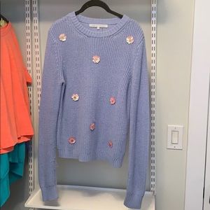 A light blue sweater with flower detailing